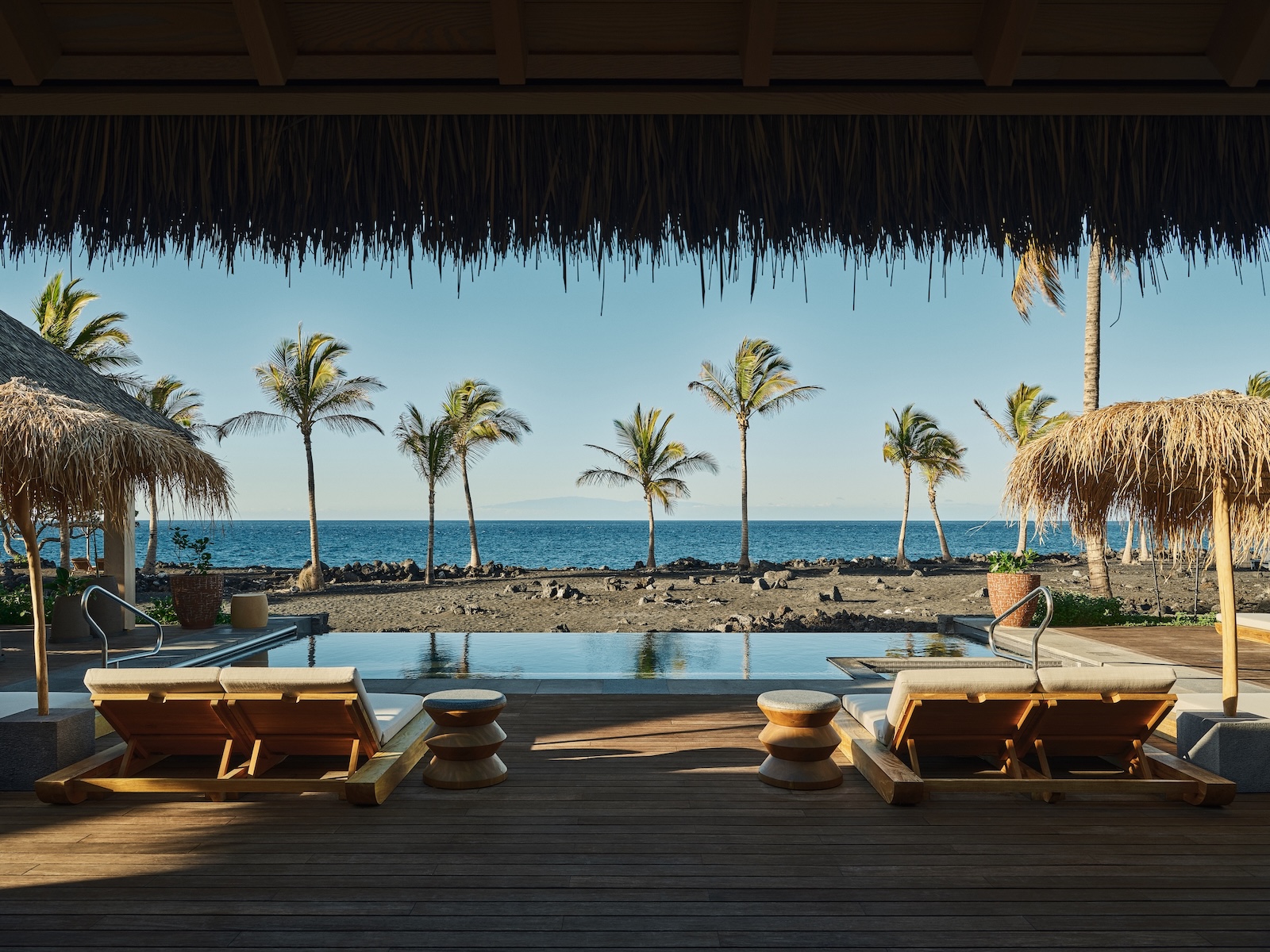 Kona Village infinity pool with ocean view and palm trees